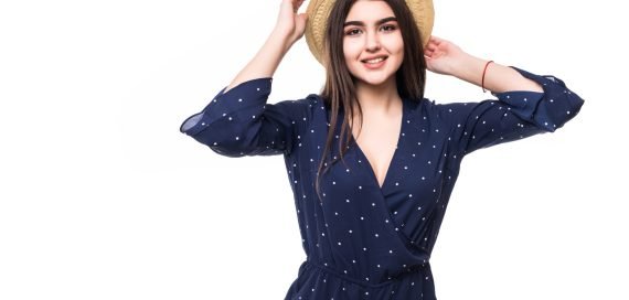 Pretty lady model in short blue dress and hat barfoot isolated on white